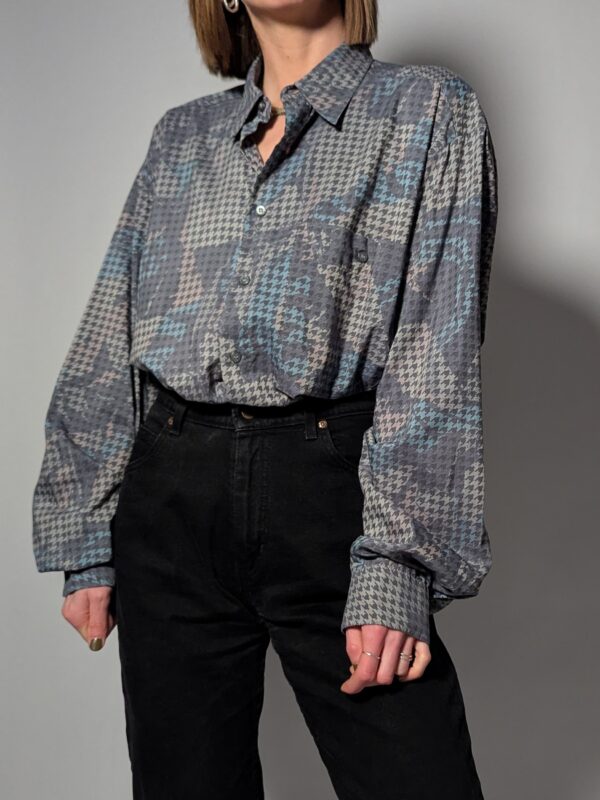 Vintage blouse met houndstooth patroon in zachte grijstinten. Licht, stijlvol en veelzijdig.