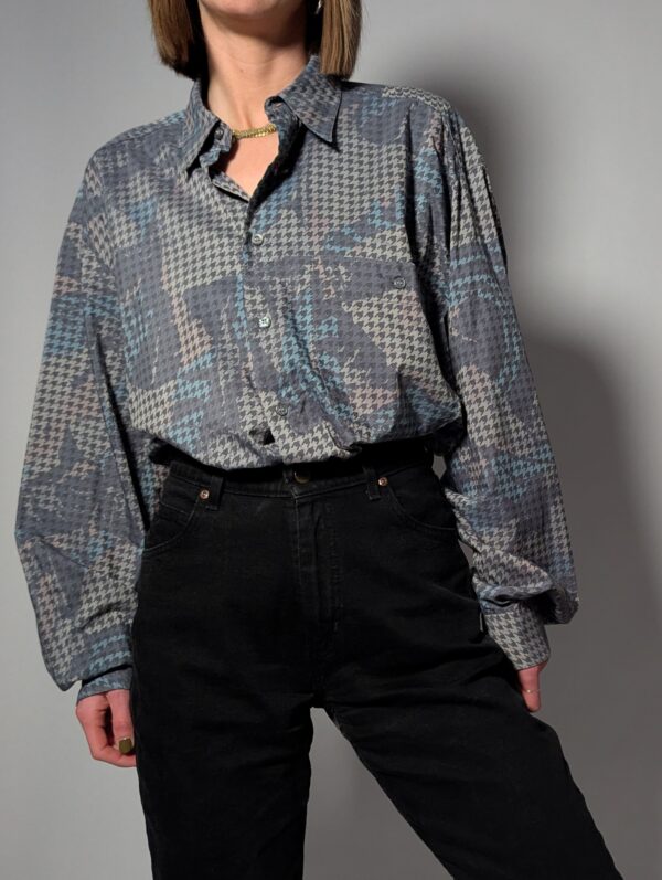 Vintage blouse met houndstooth patroon in zachte grijstinten. Licht, stijlvol en veelzijdig.