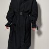 Vintage zwarte trenchcoat met ceintuur. Tijdloos silhouet en elegante uitstraling.