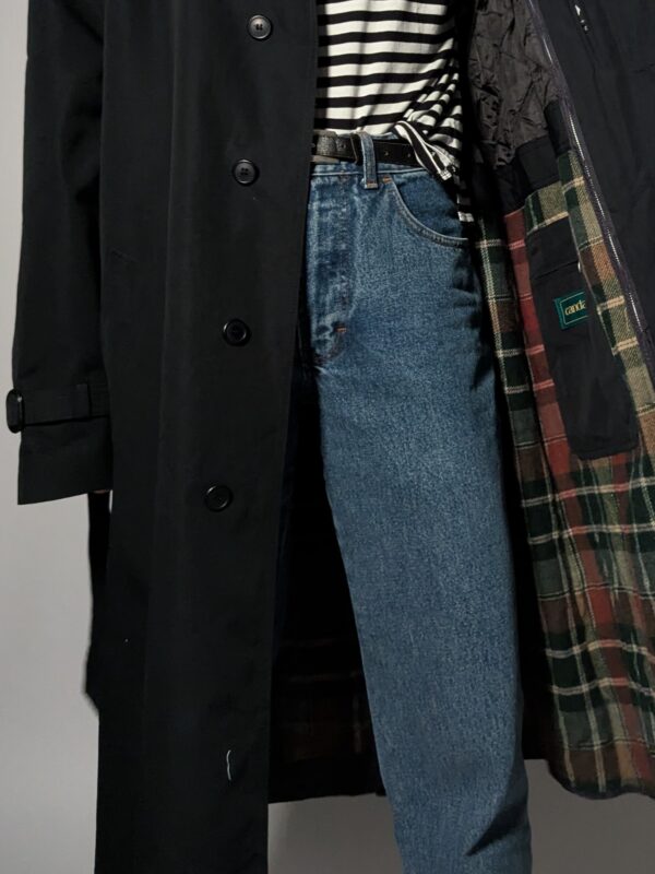 Vintage zwarte trenchcoat met ceintuur. Tijdloos silhouet en elegante uitstraling.