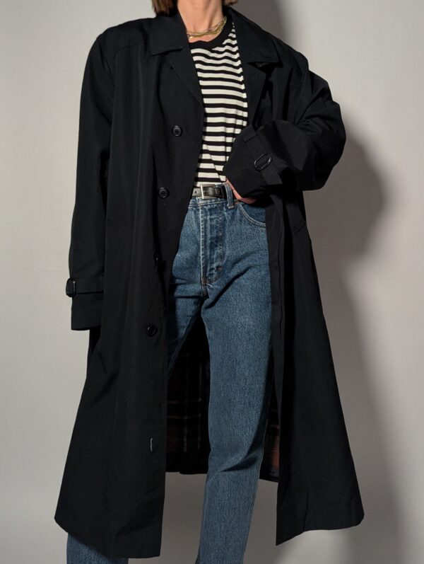 Vintage zwarte trenchcoat met ceintuur. Tijdloos silhouet en elegante uitstraling.