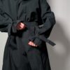 Vintage zwarte trenchcoat met ceintuur. Tijdloos silhouet en elegante uitstraling.