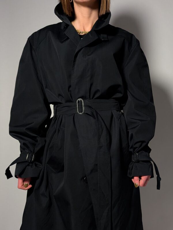 Vintage zwarte trenchcoat met ceintuur. Tijdloos silhouet en elegante uitstraling.