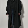 Vintage zwarte trenchcoat met ceintuur. Tijdloos silhouet en elegante uitstraling.