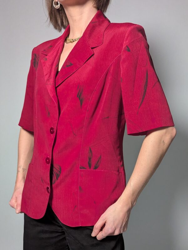 Vintage berryroze blouse-blazer met korte mouwen, glanzende knopen, subtiele bladprint en getailleerde pasvorm.