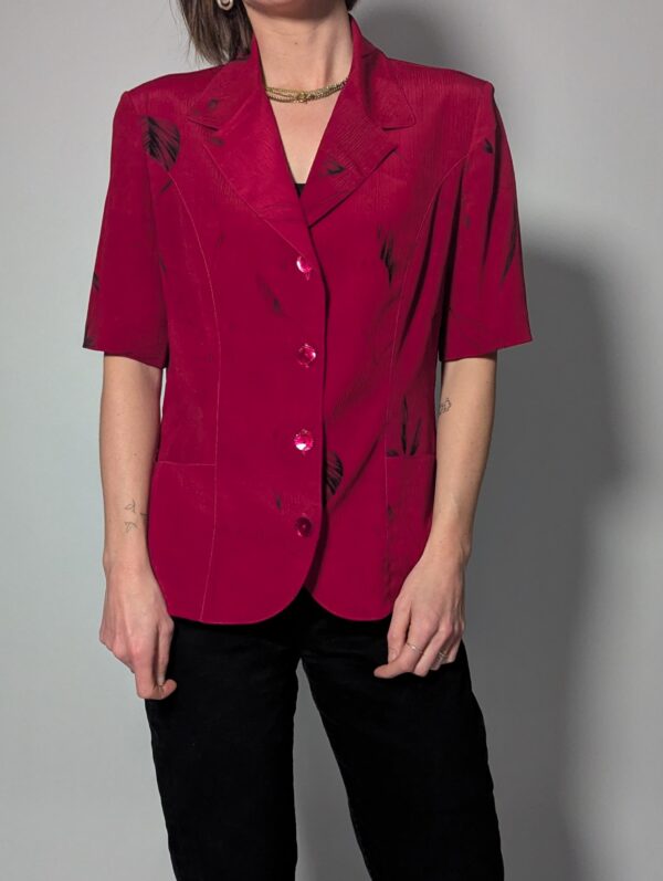 Vintage berryroze blouse-blazer met korte mouwen, glanzende knopen, subtiele bladprint en getailleerde pasvorm.
