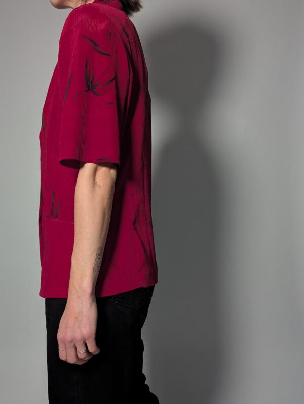 Vintage berryroze blouse-blazer met korte mouwen, glanzende knopen, subtiele bladprint en getailleerde pasvorm.