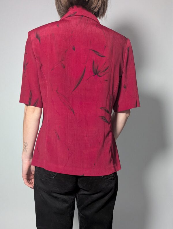 Vintage berryroze blouse-blazer met korte mouwen, glanzende knopen, subtiele bladprint en getailleerde pasvorm.