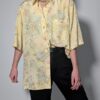 Pastelgele vintage blouse met korte mouwen, oversized fit, bloemenprint en subtiele stipdetails.