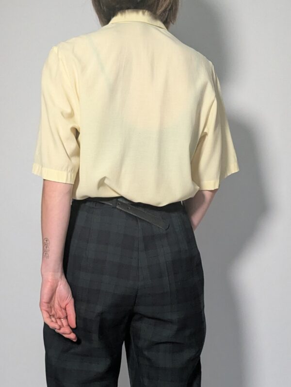 Lichtgele vintage blouse met korte mouwen, klassieke kraag en rechte soepele pasvorm.