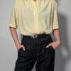 Lichtgele vintage blouse met korte mouwen, klassieke kraag en rechte soepele pasvorm.