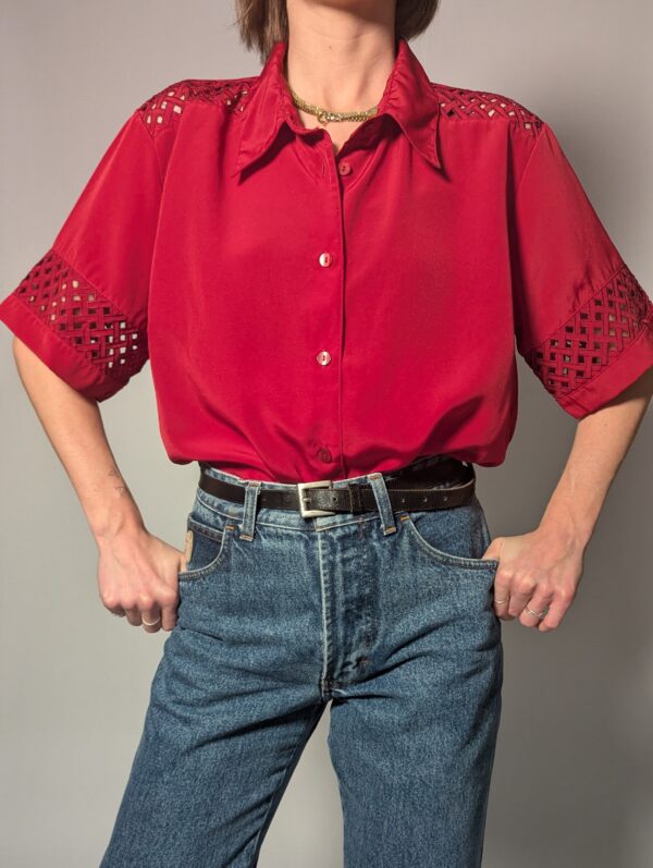 Kersenrode vintage blouse met korte mouwen, glanzende stof en opengewerkte details op schouders en mouwen.