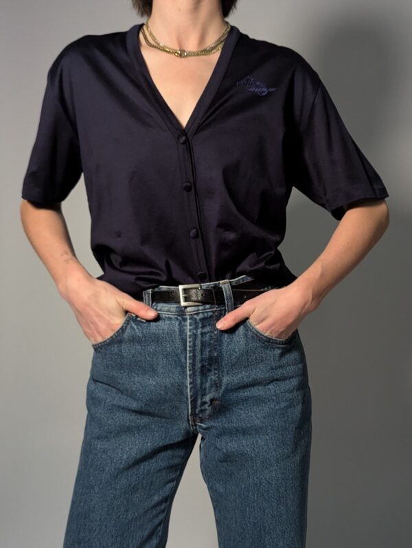 Donkerblauwe vintage topmet korte mouwen, diepe V-hals, subtiele glans en fijne knoopdetails.