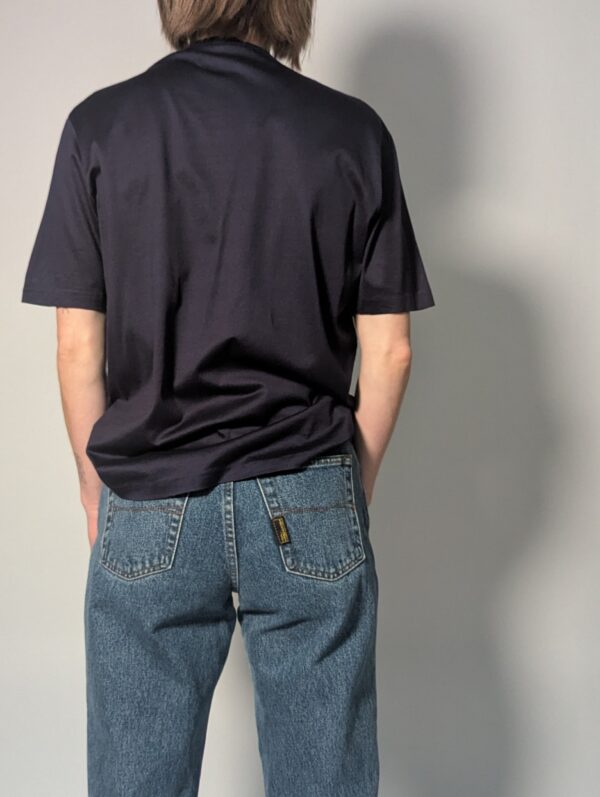 Donkerblauwe vintage topmet korte mouwen, diepe V-hals, subtiele glans en fijne knoopdetails.