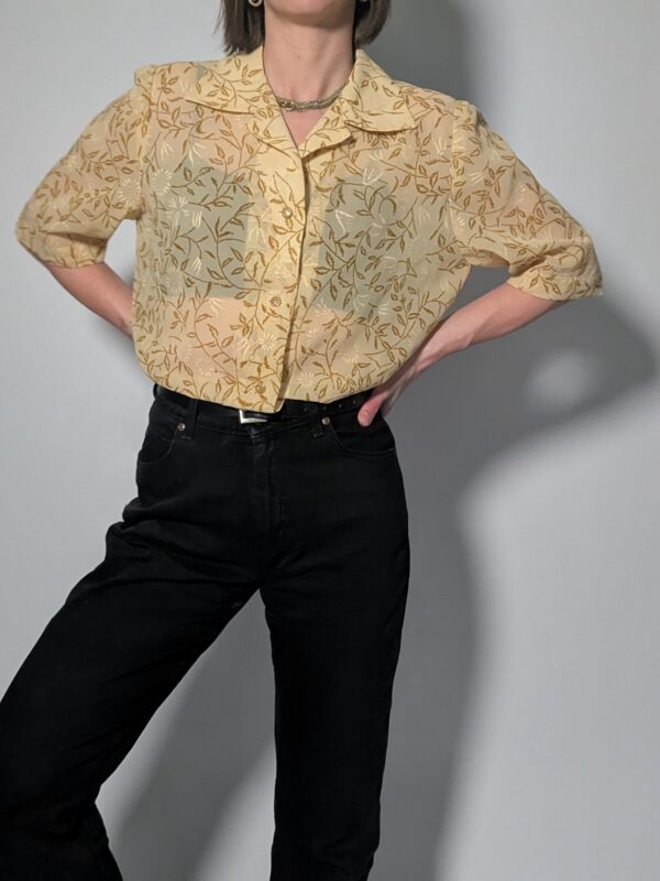 Lichtbeige vintage blouse met korte mouwen, botanische print in honingtinten en elegante kraag.