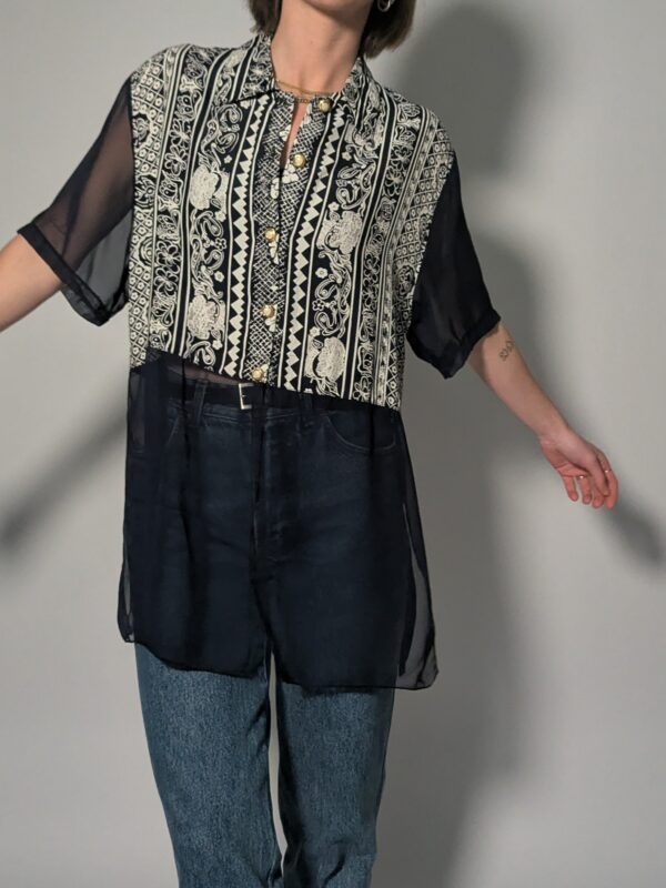 Lange vintage semi-transparante donkerblauwe blouse met donkerblauw-witte grafische print en goudkleurige knopen.