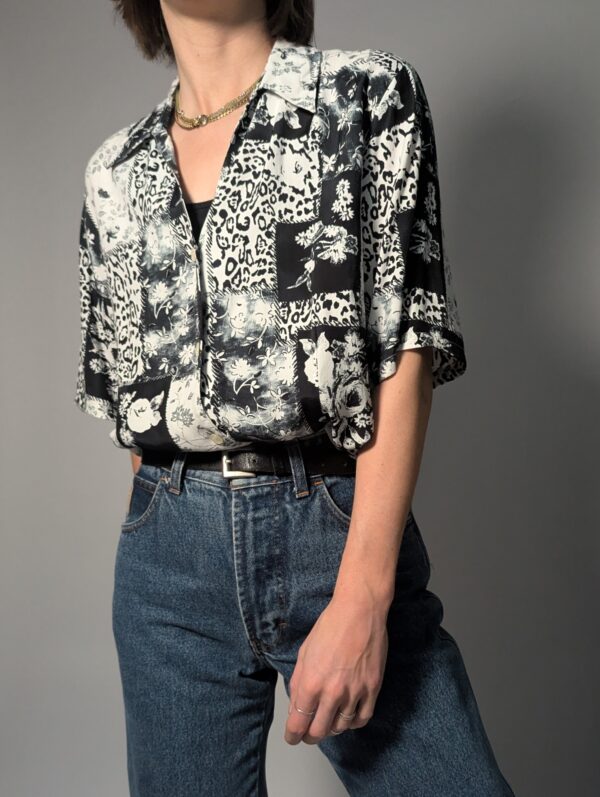 Zwart-witte vintage blouse met korte mouwen en gemixte patchwork print van bloemen- en animal motieven.