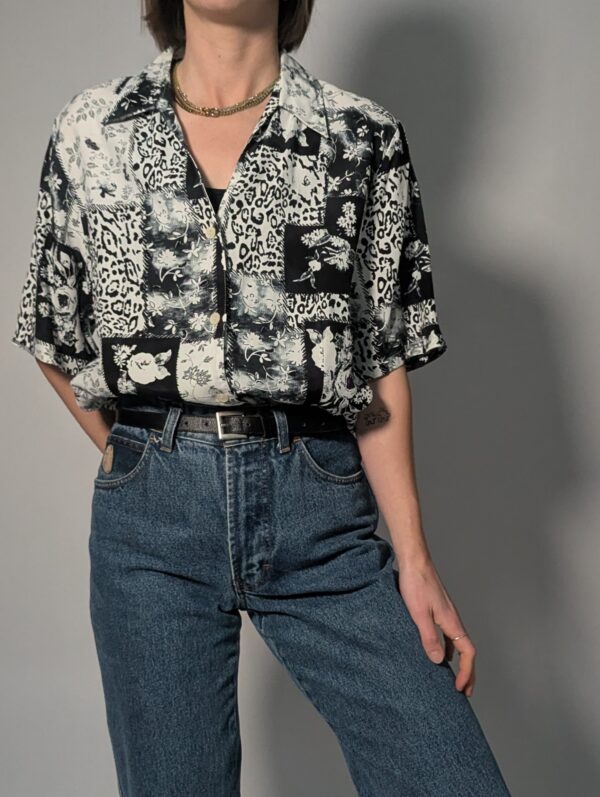 Zwart-witte vintage blouse met korte mouwen en gemixte patchwork print van bloemen- en animal motieven.