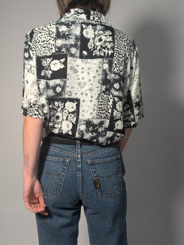 Zwart-witte vintage blouse met korte mouwen en gemixte patchwork print van bloemen- en animal motieven.