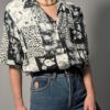 Zwart-witte vintage blouse met korte mouwen en gemixte patchwork print van bloemen- en animal motieven.