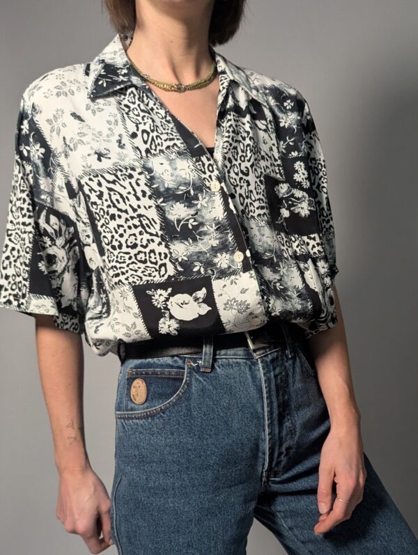 Zwart-witte vintage blouse met korte mouwen en gemixte patchwork print van bloemen- en animal motieven.