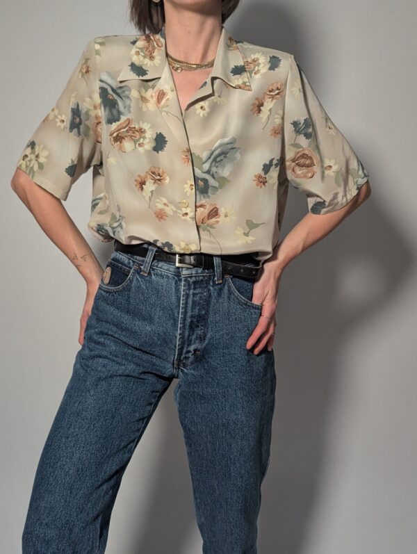 Vintage blouse met korte mouwen in zachte zandtint met bloemenprint in blauw, crème en warme nudetinten.