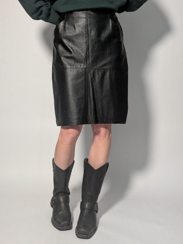 Zwarte vintage leren rok tot boven de knie met rechte pasvorm en minimalistisch ontwerp.