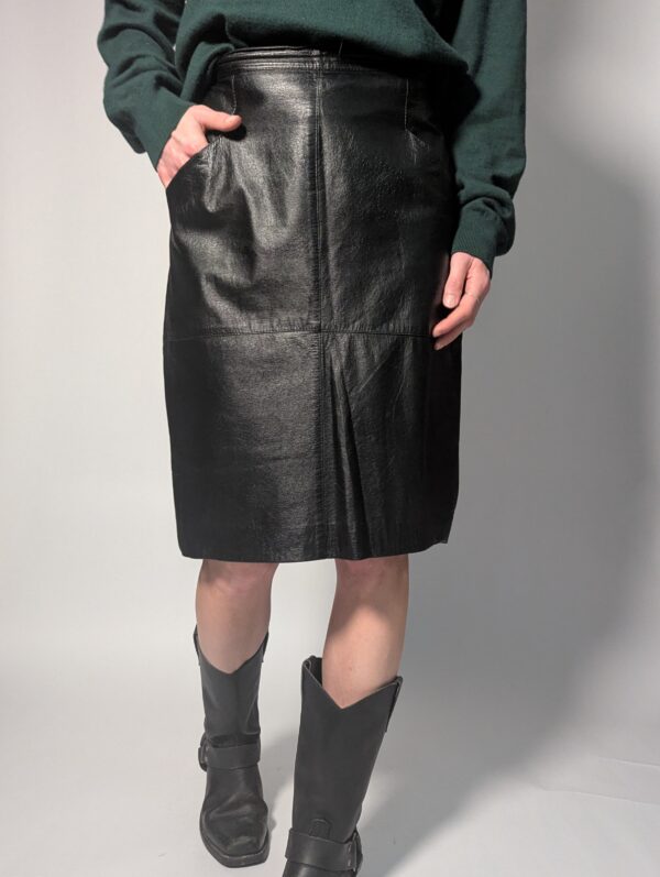 Zwarte vintage leren rok tot boven de knie met rechte pasvorm en minimalistisch ontwerp.