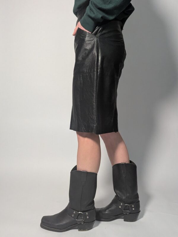 Zwarte vintage leren rok tot boven de knie met rechte pasvorm en minimalistisch ontwerp.