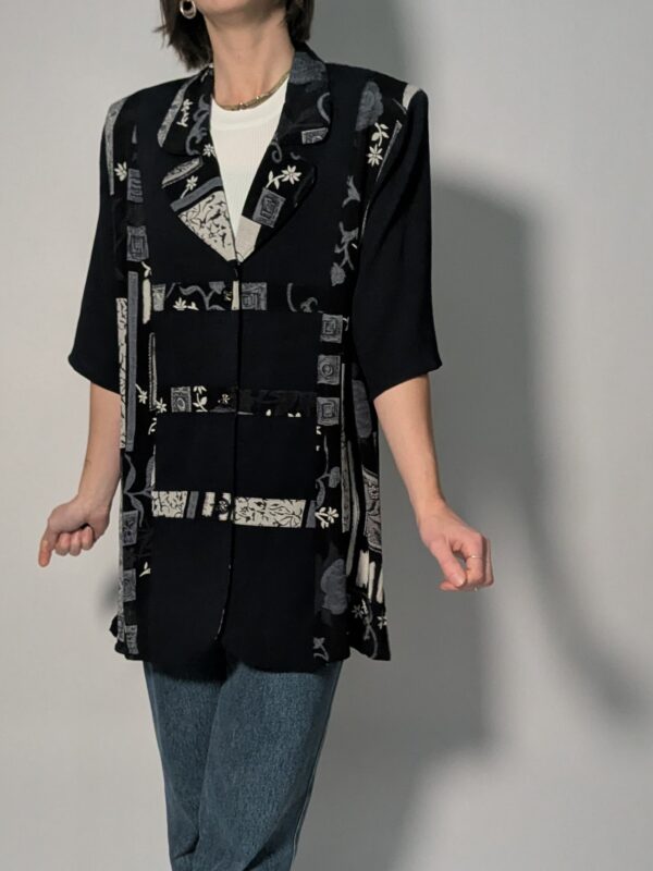 Zwarte vintage lange blouse met korte mouwen en grafisch patchworkpatroon in zwart-wit en grijstinten.