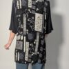 Zwarte vintage lange blouse met korte mouwen en grafisch patchworkpatroon in zwart-wit en grijstinten.