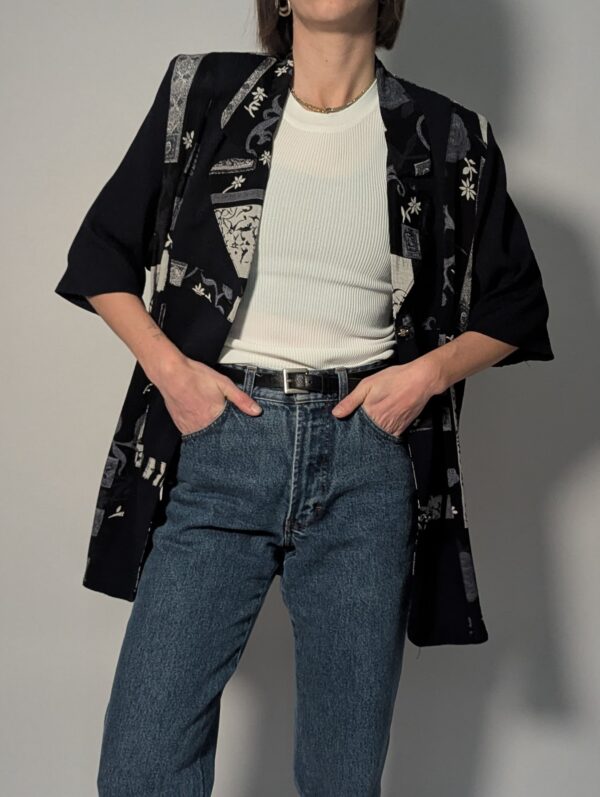 Zwarte vintage lange blouse met korte mouwen en grafisch patchworkpatroon in zwart-wit en grijstinten.