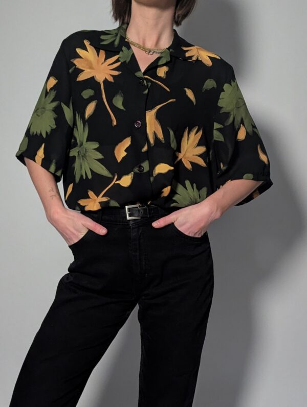 Zwarte vintage blouse met korte mouwen en grote bloemenprint in groen- en geeltinten.