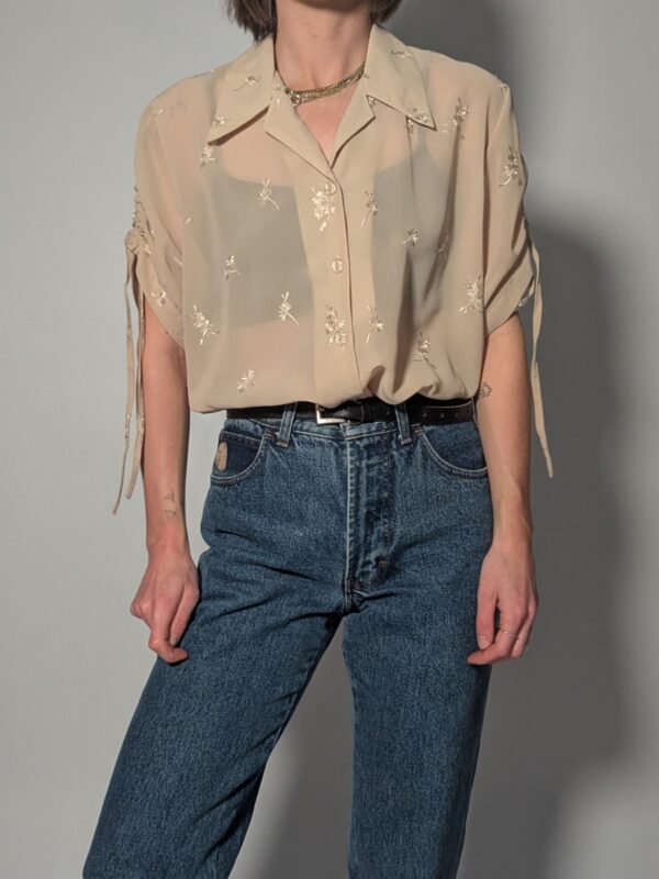 Semi-transparante vintage blouse in zandtint met geborduurde bloemetjes, korte mouwen en luchtige pasvorm.