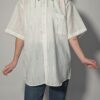 Witte vintage blouse met korte mouwen, oversized fit, borstzak en subtiele glanzende verticale strepen.