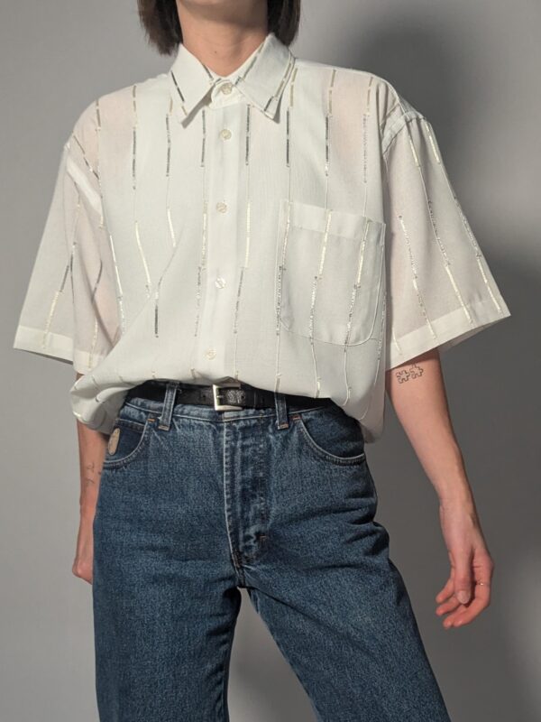 Witte vintage blouse met korte mouwen, oversized fit, borstzak en subtiele glanzende verticale strepen.
