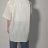Witte vintage blouse met korte mouwen, oversized fit, borstzak en subtiele glanzende verticale strepen.