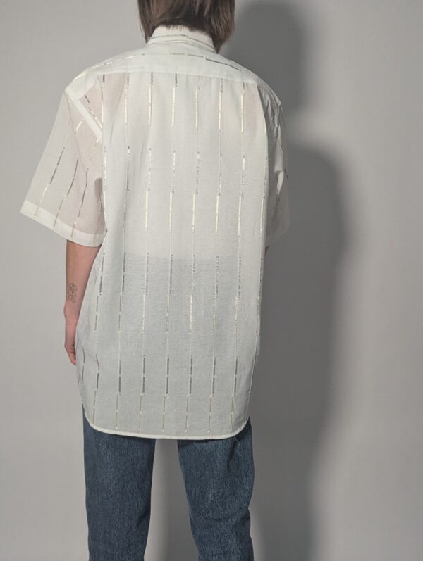 Witte vintage blouse met korte mouwen, oversized fit, borstzak en subtiele glanzende verticale strepen.
