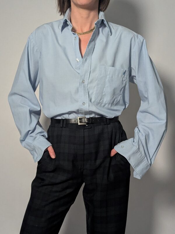 Lichtblauwe vintage blouse met lange mouwen, klassieke kraag, borstzak en rechte relaxte pasvorm.