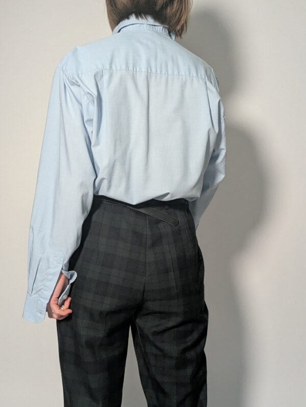 Lichtblauwe vintage blouse met lange mouwen, klassieke kraag, borstzak en rechte relaxte pasvorm.