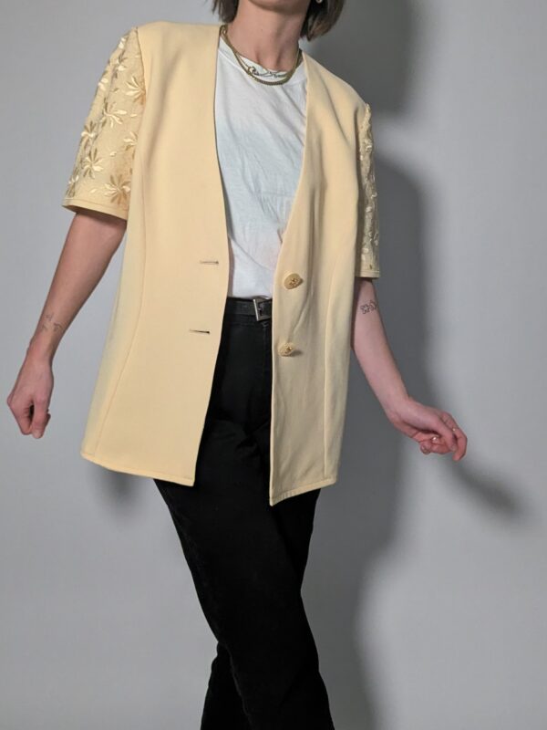 Vintage lichtgele blazer met korte mouwen met bloemenkant, diepe V-hals en lange getailleerde pasvorm.