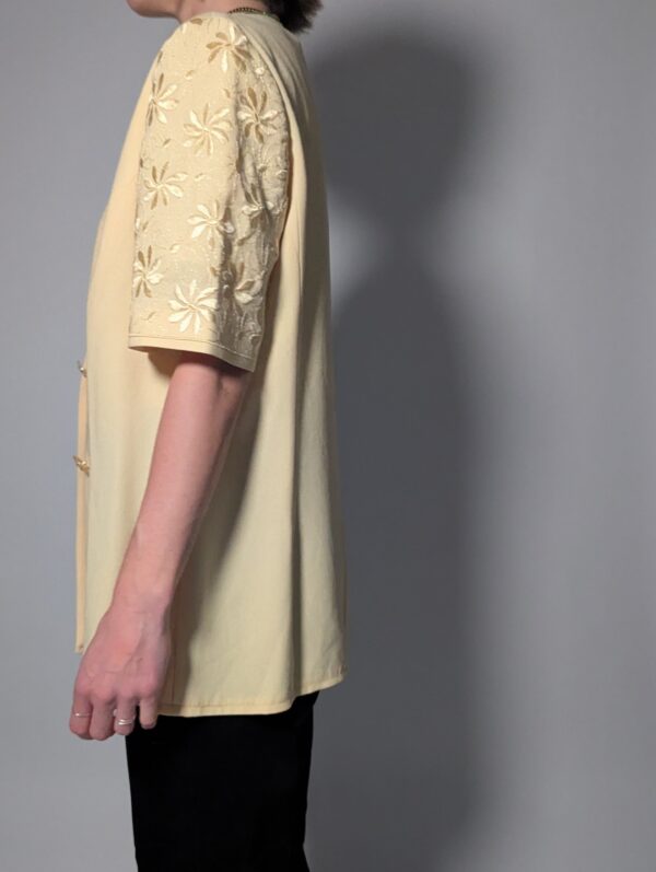 Vintage lichtgele blazer met korte mouwen met bloemenkant, diepe V-hals en lange getailleerde pasvorm.