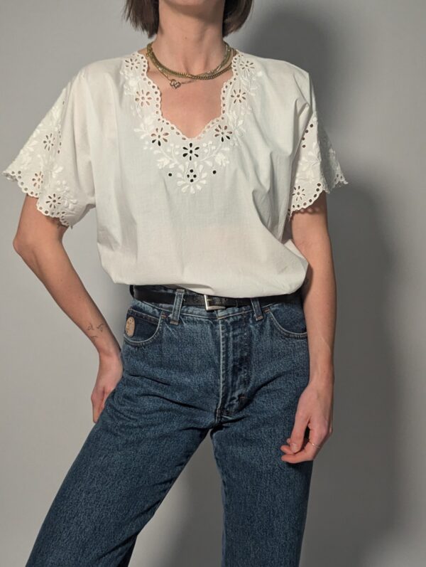 Witte vintage blouse met korte mouwen, broderie details en sierlijke V-hals.