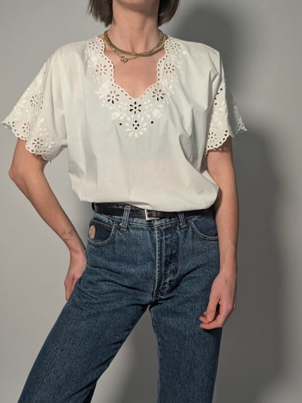 Witte vintage blouse met korte mouwen, broderie details en sierlijke V-hals.