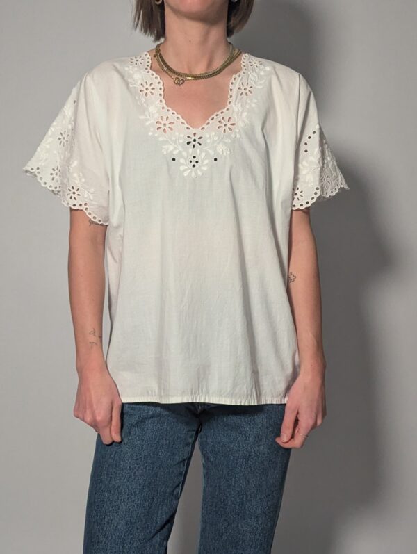 Witte vintage blouse met korte mouwen, broderie details en sierlijke V-hals.