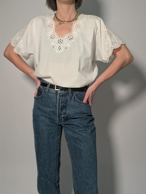 Witte vintage blouse met korte mouwen, broderie details en sierlijke V-hals.