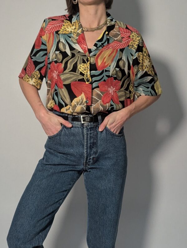 Wild bloom - 04 Vintage blouse met korte mouwen, zwarte basis en kleurrijke bloemen- en bladprint in rood, geel, groen en blauw.