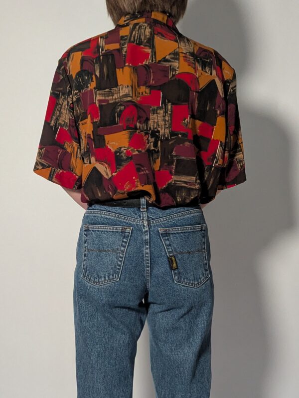 Vintage blouse met korte mouwen en abstracte print in amber, bordeaux, zwart en dieprode tinten.