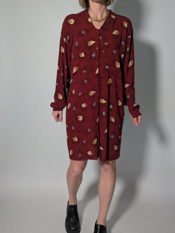 Berry leaf 01 Vintage bordeauxrode jurk met lange mouwen, knoopsluiting en subtiele print van blaadjes en kleine bloemdetails, zonder riem.