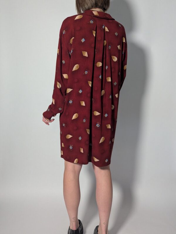 Berry leaf 03 Vintage bordeauxrode jurk met lange mouwen, knoopsluiting en subtiele print van blaadjes en kleine bloemdetails, zonder riem.